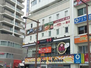 桃菜をはじめ複数の飲食店の看板が並ぶ、都市部の商業ビル外観の写真