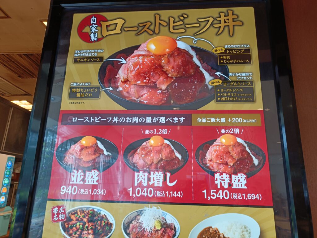 ローストビーフ丼やからあげ丼など数種類の肉丼の写真と価格が載った、肉丼の星のカラフルなメニュー看板のクローズアップ写真