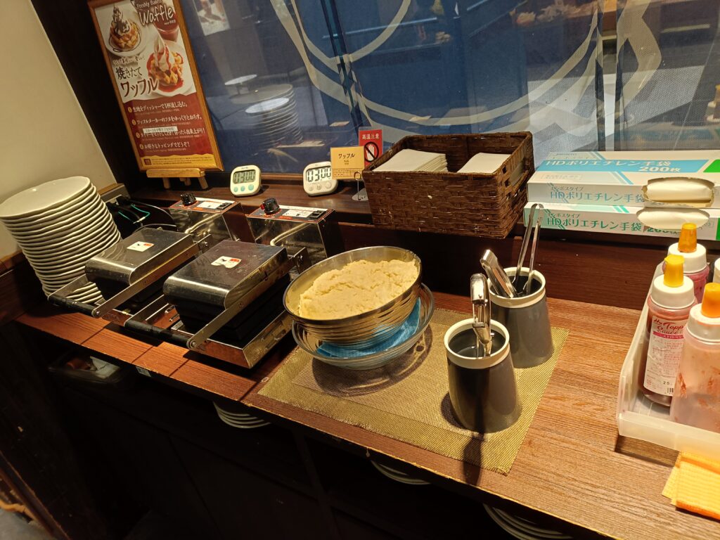 テーブルの上にしゃぶしゃぶ鍋、ご飯のおひつ、タレや薬味の器が並んでいる菜の庵の卓上写真。