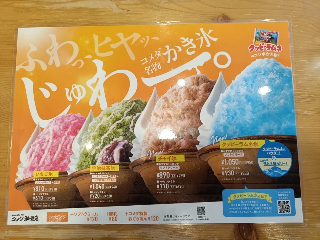 「コメダ珈琲店の壁に貼られた季節限定スイーツの大きなポスター。色とりどりのかき氷やデザートの写真が並んでいる」