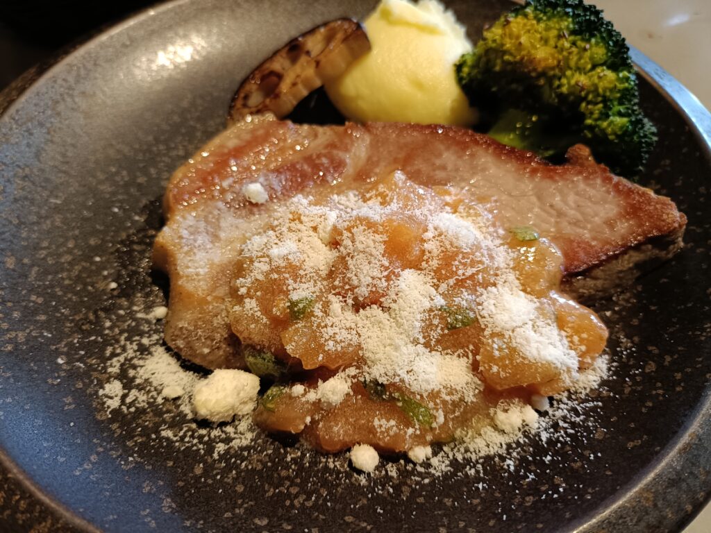 「グッドモーニングカフェで提供されるお肉のグリルプレートランチ。メインの肉料理とポテト、野菜がワンプレートに盛られている」