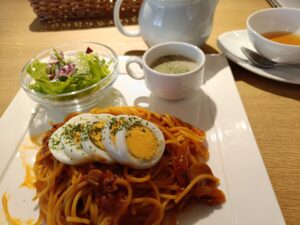 「CAFE ECLAのナポリタンランチセット。目玉焼きトッピングのパスタとミニサラダ、スープ、ドリンクがワンプレートで並んでいる」