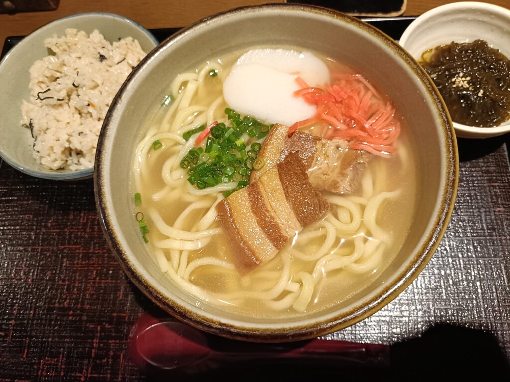 「海人酒房の沖縄そば定食。ラフテーと半熟卵、紅しょうががのった沖縄そばと、ジューシーご飯がセットになった和風トレイ」