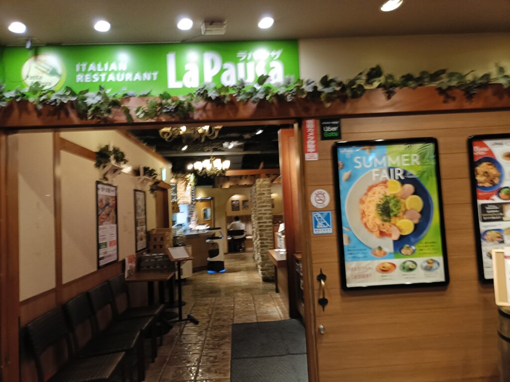 ラパウザの店舗入口と看板（La Pausaロゴ）が見える外観写真