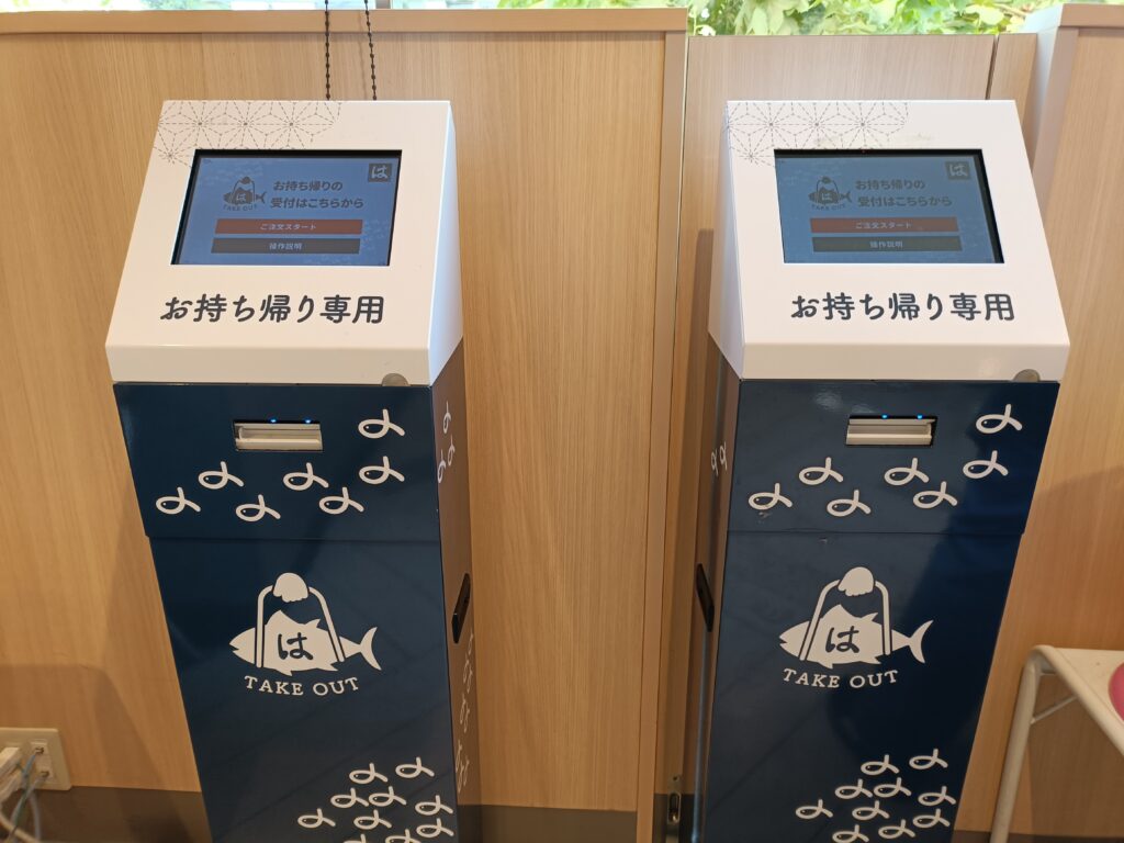 はま寿司のテイクアウト受け取り端末（画面付き）。持ち帰り用の案内が表示されている。