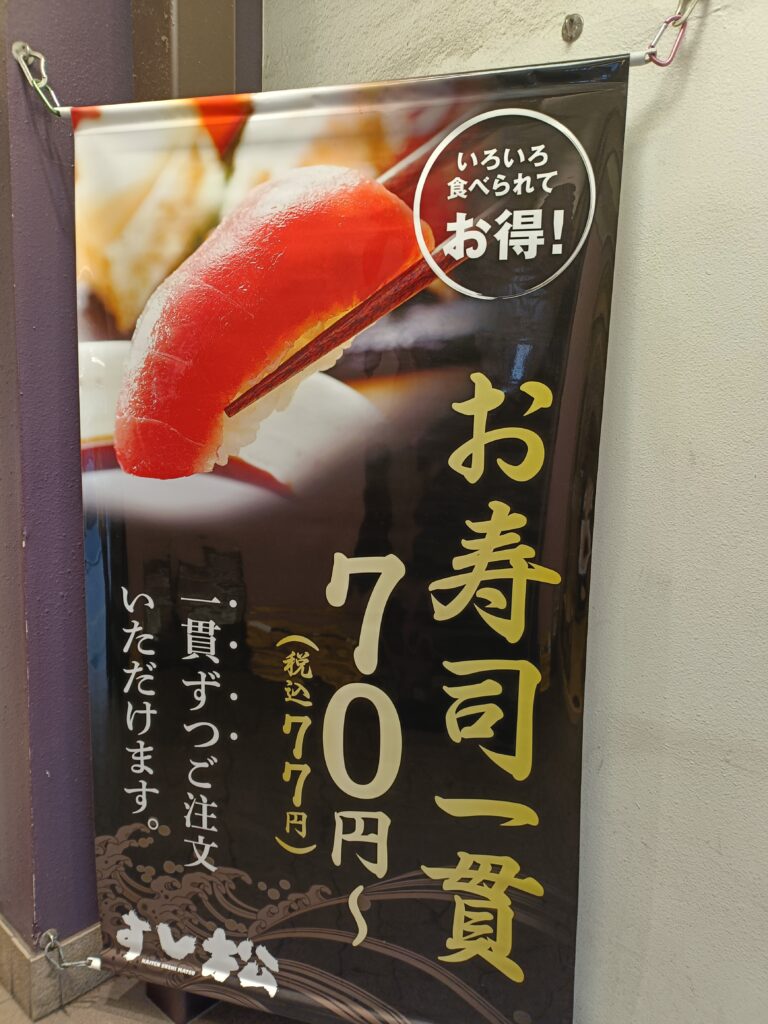すし松の店頭ポスター。寿司の写真と価格・キャンペーン告知が掲載されている。