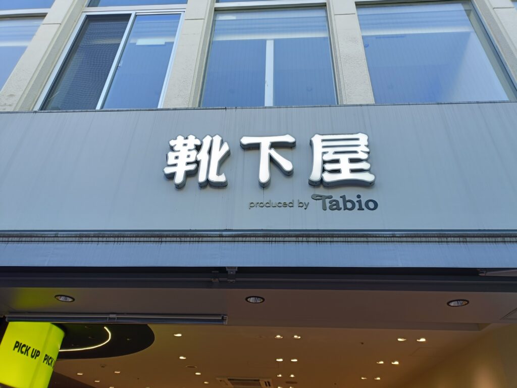 「ビルの1階に『靴下屋』の大きな文字とTabioロゴが付いた看板が見える店舗外観」