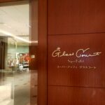 「木製の壁面に英字で『Glass Court Super Buffet Restaurant』と書かれた京王プラザホテル新宿レストランのロゴプレート」