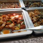 「酢豚や野菜炒めなど複数の中華料理がステンレス容器に入れられた香港蒸籠のホットビュッフェコーナー」