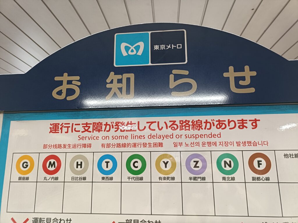 東京メトロ駅構内に掲示されたお知らせ看板と、各路線を示す丸い路線記号。