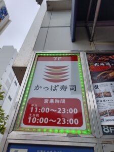 かっぱ寿司の店舗前にある縦長の案内看板。店名と営業時間が見える。