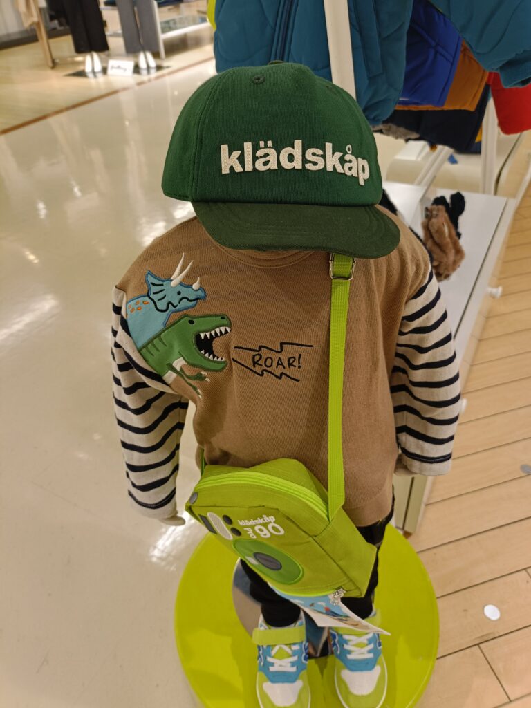 kladskap（クレードスコープ）のキッズコーデ例。ロゴ入りキャップと明るいカラーのアイテムを合わせた着こなし。