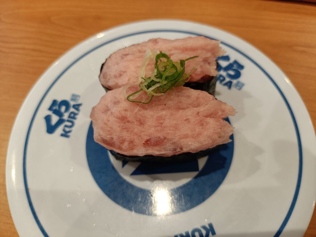 くら寿司の皿にのったねぎまぐろ軍艦2貫、刻みねぎがトッピングされた軍艦寿司のアップ写真